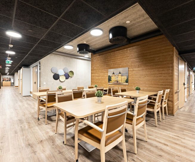 Chairs and tables in a wooden lobby area.