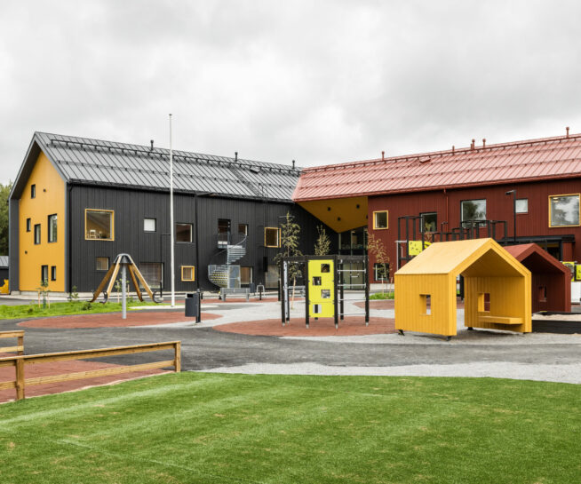 Red and black L-shaped building and playground.